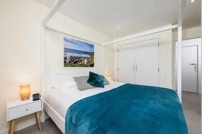 a bedroom with a large bed with a blue blanket at 32 Tre Lowen in Newquay