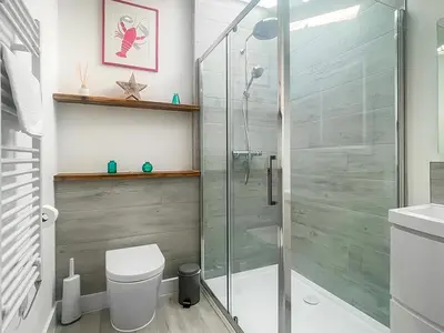 a bathroom with a glass shower and a toilet at Penty Lowen in Saint Mawes