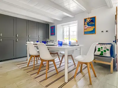 a dining room with a white table and chairs at Penty Lowen in Saint Mawes