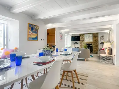 a white dining room with a table and chairs at Penty Lowen in Saint Mawes