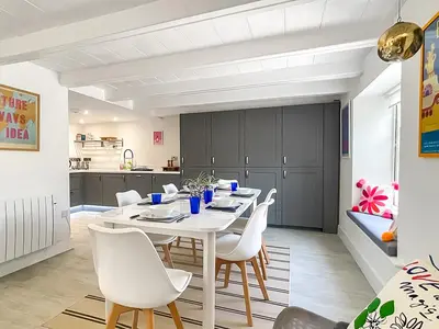 a dining room with a white table and white chairs at Penty Lowen in Saint Mawes