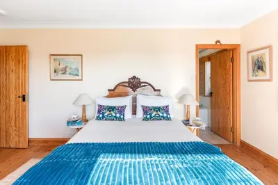 a bedroom with a large bed with blue and white sheets at Peaceful cottage with views - Fairview Cottage in Mylor Bridge
