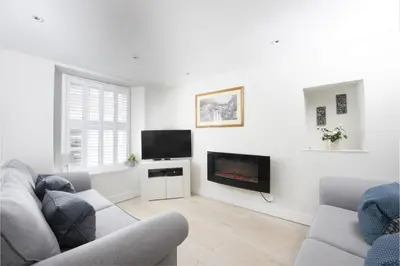 a living room with a couch and a flat screen tv at 4 Quayside - Centre of Fowey - Pet Allowed - Free WiFi in Fowey