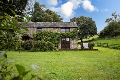 an old stone house on a green field at Myrtle Grove in Saint Endellion