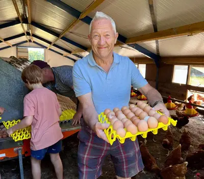 an older man holding a bunch of eggs in a barn at Myrtle Grove in Saint Endellion