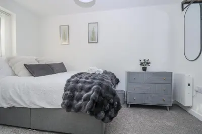 a bedroom with a bed with a blanket on it at Cosy Retreat in Camborne