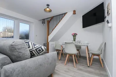 a living room with a couch and a table and chairs at Cosy Retreat in Camborne