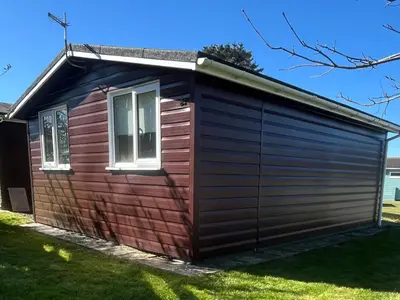 a large wooden shed with a window at Stanbury in Padstow