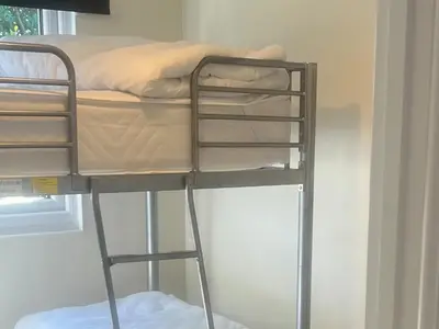 a bunk bed with a ladder next to a window at Stanbury in Padstow
