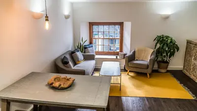 a living room with a table and chairs at Mor Ki -A perfectly situated modern flat in Looe in Looe