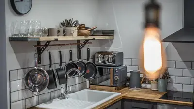 a kitchen with a sink and utensils on the wall at Mor Ki -A perfectly situated modern flat in Looe in Looe
