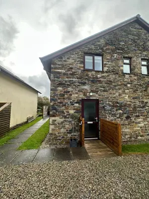 a brick building with a door on the side of it at Wave Side Lodge 106B- Retallack Resort & Spa in Saint Columb Major