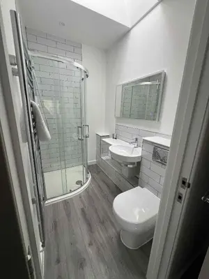 a bathroom with a shower and a toilet and a sink at Wave Side Lodge 106B- Retallack Resort & Spa in Saint Columb Major