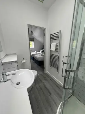 a white bathroom with a sink and a shower at Wave Side Lodge 106B- Retallack Resort & Spa in Saint Columb Major