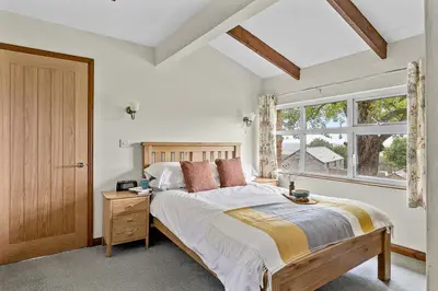 a bedroom with a large bed and a window at Fuchsia Cottage in Saint Endellion