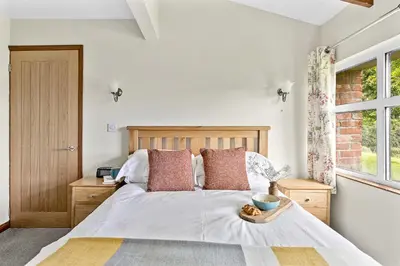 a bedroom with a bed and a window at Fuchsia Cottage in Saint Endellion