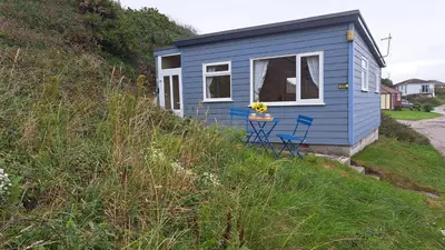 a blue tiny house on the side of a hill at D17 Vellanoweth, Riviere Towans in Hayle