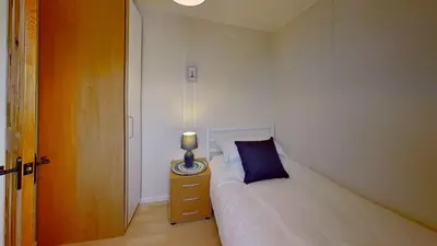 a bedroom with a bed and a lamp on a night stand at D17 Vellanoweth, Riviere Towans in Hayle