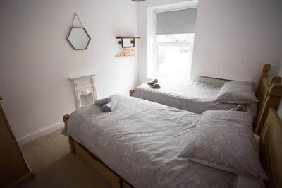 a bedroom with two beds and a window at Stone's Throw // Central Newquay // Parking in Newquay
