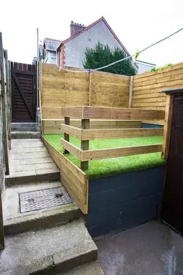 a wooden fence with grass on top of it at Stone's Throw // Central Newquay // Parking in Newquay