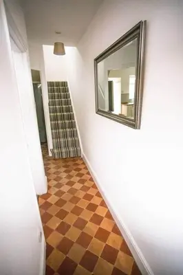 a hallway with a mirror and a checkered floor at Stone's Throw // Central Newquay // Parking in Newquay