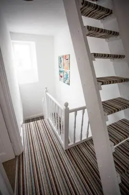 a room with a staircase with a ceiling and a staircase at Stone's Throw // Central Newquay // Parking in Newquay