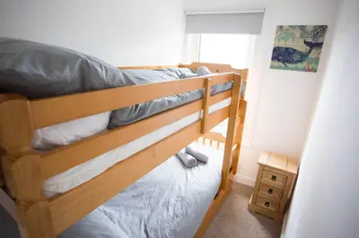 a bedroom with two bunk beds and a window at Stone's Throw // Central Newquay // Parking in Newquay