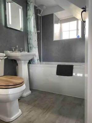 a bathroom with a toilet and a sink and a bath tub at Buntings Cottage at Trenale Court Cottages in Tintagel