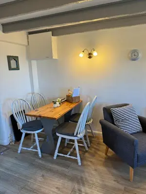 a dining room with a wooden table and chairs at Buntings Cottage at Trenale Court Cottages in Tintagel