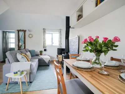 a living room with a table and a couch at Bramble Cottage in Saint Columb Minor
