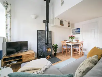 a living room with a couch and a fireplace at Bramble Cottage in Saint Columb Minor