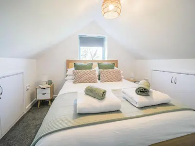 a bedroom with a large bed with two pillows on it at Bramble Cottage in Saint Columb Minor