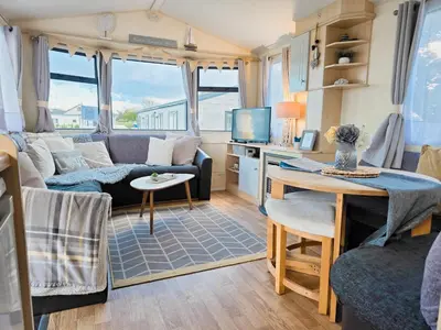 a caravan living room with a couch and a table at Ocean Breeze in Truro