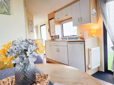 a kitchen with a table with a vase of flowers at Ocean Breeze in Truro