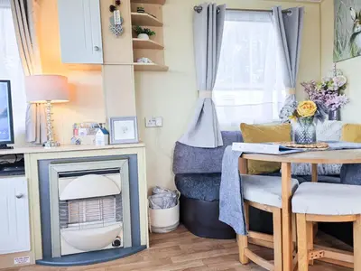 a living room with a fireplace and a table at Ocean Breeze in Truro