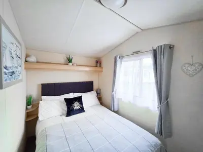 a small bedroom with a bed and a window at Ocean Breeze in Truro