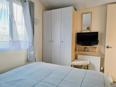 a bedroom with a bed and a tv and a window at Ocean Breeze in Truro