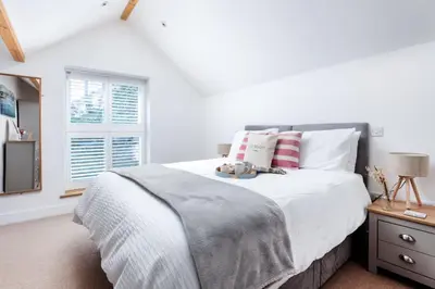 a bedroom with a large bed with white sheets and pillows at Wavecrest in Portreath