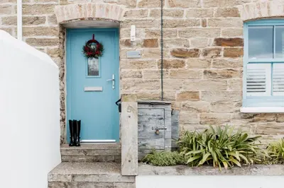a blue door on a stone house with a wreath at Wavecrest in Portreath