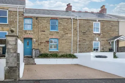 a brick house with a blue door at Wavecrest in Portreath