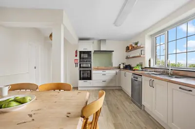 a kitchen with a wooden table and a dining room at Rose Cottage in Port Isaac
