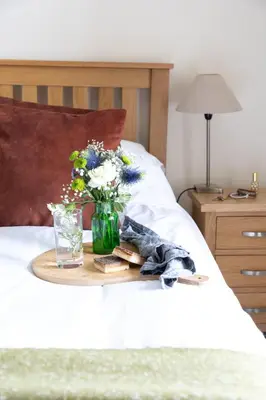 a tray with a vase of flowers on a bed at Rose Cottage in Port Isaac