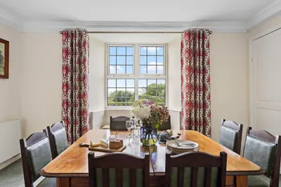 a dining room with a table and a window at Rose Cottage in Port Isaac