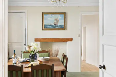 a dining room with a wooden table and chairs at Rose Cottage in Port Isaac