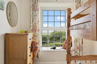 a bedroom with a loft bed and a window at Rose Cottage in Port Isaac