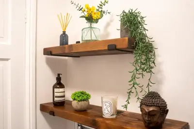 a shelf with a bottle of wine and plants at Ye Old Mill - Stylish cosy retreat with parking in Penryn