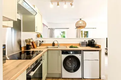 a kitchen with a washing machine and a sink at Ye Old Mill - Stylish cosy retreat with parking in Penryn