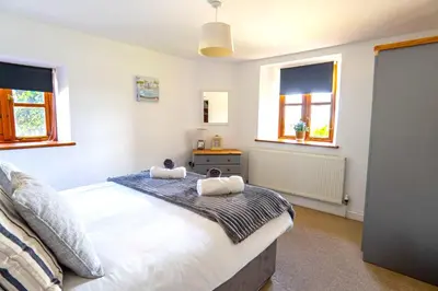a bedroom with a bed with two stuffed animals on it at Finest Retreats - Fields Barn in Widemouth Bay