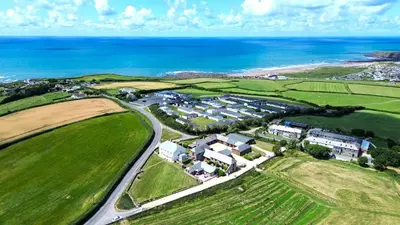 an aerial view of a house next to the ocean at Finest Retreats - Fields Barn in Widemouth Bay