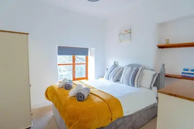 a bedroom with a bed with towels on it at Finest Retreats - Rosemary Cottage in Widemouth Bay